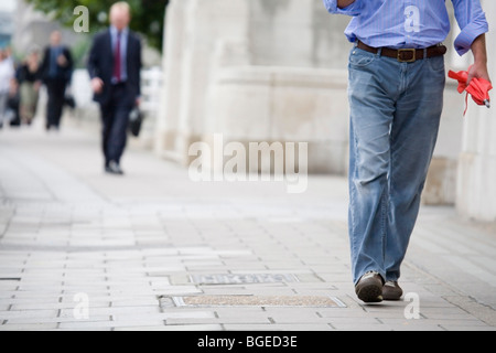 Pendler in Business- und Freizeitkleidung Fuß zur Arbeit über Waterloo Bridge, London, England. Keine erkennbaren Gesichter oder Logos. Stockfoto