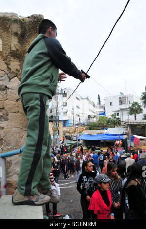 Junge arabische jungen weist eine Handfeuerwaffe in die Menge Stockfoto