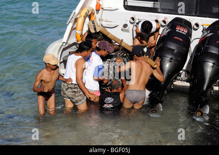 Mechaniker nehmen Sie das Motorboot am Strand Padang Bai, Bali, Indonesien Stockfoto