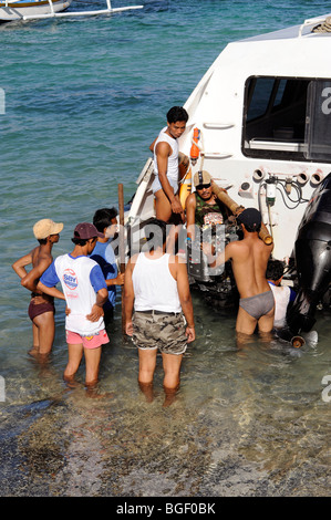 Mechaniker nehmen Sie das Motorboot am Strand Padang Bai, Bali, Indonesien Stockfoto