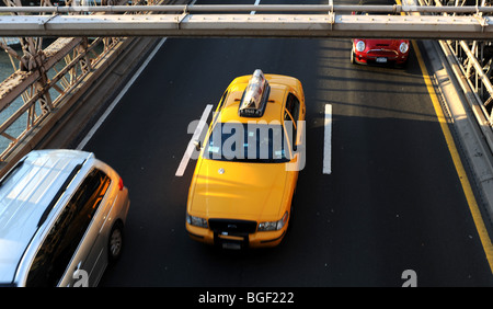Gelbes Taxi fährt unter der Brooklyn Bridge in Manhattan New York USA vorbei Stockfoto
