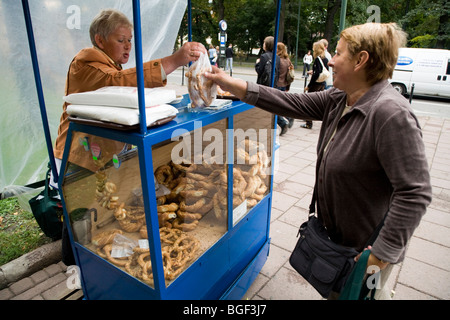 Frau auf Bagel Stand mit Bagels an einen Kunden in Krakau, Polen. Stockfoto