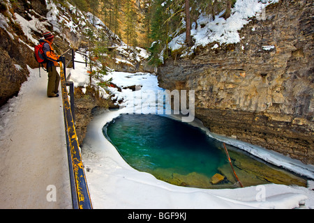 Als Tourist hält auf dem Weg nach einem Pool ansehen, die entlang der Johnston Creek, umgeben von Schnee und Eis während wi gebildet hat Stockfoto