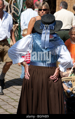 Alte Frau stehend mit ihren Händen auf ihre Taille als Touristen roaming auf dem Markt in Bayern, Deutschland Stockfoto