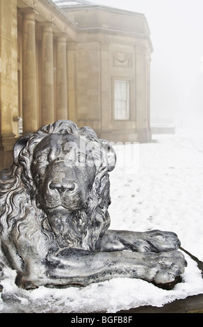 Löwe auf vorderen Stufen von Heaton Hall im Winter verschneit und nebligen Bedingungen, Heaton Park, Manchester, UK Stockfoto