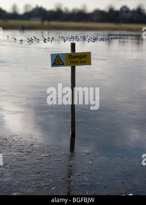 Gefahr, dünnem Eis, Wegweiser auf zugefrorenen Teich, Wimbledon Common, London Stockfoto