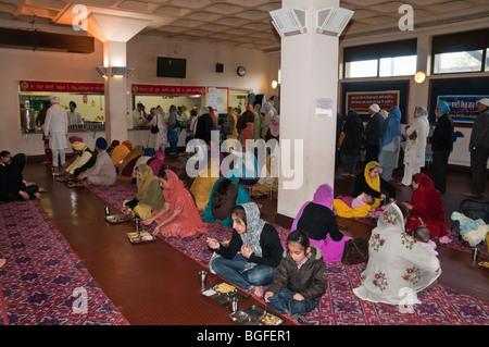 Sikhs genießen Sie das kostenlose vegetarische Essen in Langar (Gemeinschaftsküche) in Hounslow Gurdwara vor Vaisakhi Prozession Stockfoto