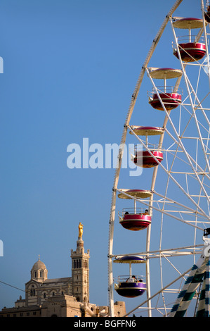 Riesenrad, Vergnügungspark & Passenger Pods mit Blick auf die Kirche Notre-Dame de la Garde, Marseille oder Marseille Bouches-du-Rhone Provence Frankreich Stockfoto