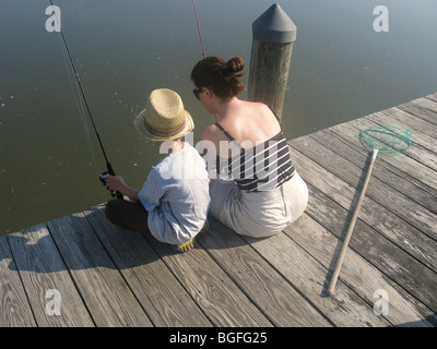 Mutter und Sohn sitzen auf einem hölzernen Dock Angeln Stockfoto