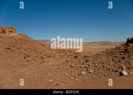 Böschung in der Sahara mit Tinghir einer Kleinstadt und dem hohen Atlas-Gebirge in der Ferne, Marokko Stockfoto