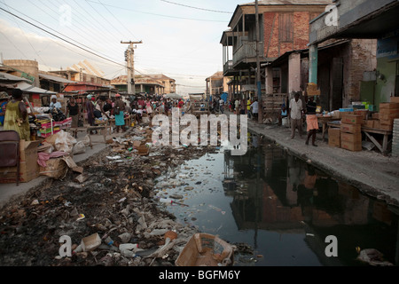 Straßenszene in Gonaives, Abteilung Artibonite, Haiti, zeigt eine unvollständige Entwässerungskanal mit Müll gefüllt. Stockfoto