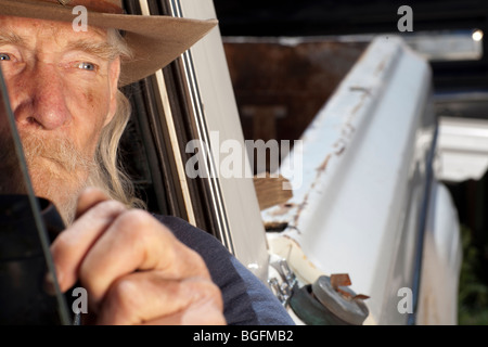 Ein älterer Mann mit einem weißen Bart ein Pickup-Truck zu fahren und starrte aus dem Fenster Stockfoto