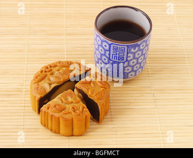 Chinesische Mooncake und Tasse Tee auf Bambusmatte Stockfoto