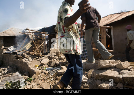 Plünderer stehlen Möbel aus brennenden Häusern in einer Nachbarschaft in Kisumu, Kenia während Gewalt das Land nach den Wahlen. Stockfoto