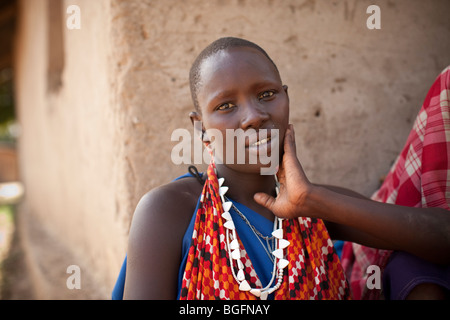 Eine Massai-Frau in traditioneller Kleidung wartet draußen eine Klinik in Kilombero Dorf, Manyara Region, Tansania. Stockfoto