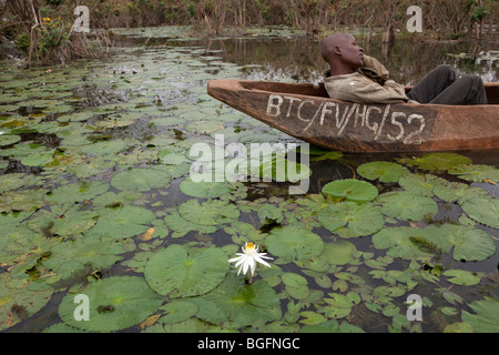 Ein Mann liegt in einem Boot auf See Babati, Tansania, Ostafrika. Stockfoto