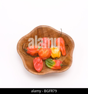 Gemischte Caribbean scotch Bonnet Chilis in Holzschale vor weißem Hintergrund Stockfoto