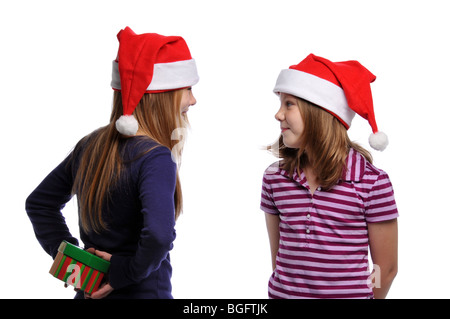 Zwei Mädchen teilen ein Weihnachtsgeschenk isoliert auf weißem Hintergrund Stockfoto