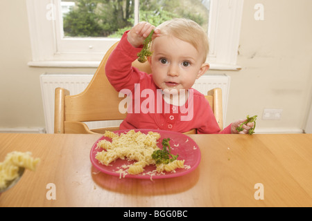 Kleinkind am Tisch essen Pasta und sprießen Brokkoli Stockfoto