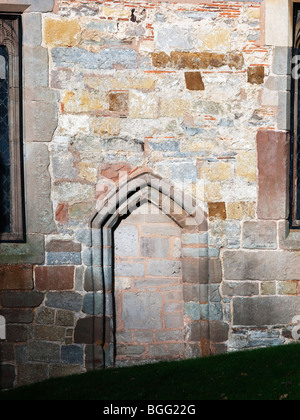 die auf gemauerten Torbogen und die Tür von einer alten Pfarrkirche Dorf Stockfoto