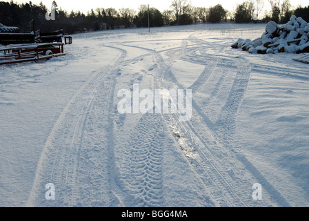 Fahrzeugspuren im frischen Schnee auf einem Bauernhof in Hampshire Stockfoto