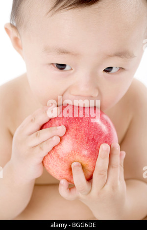Kleinkind mit Apfel Stockfoto