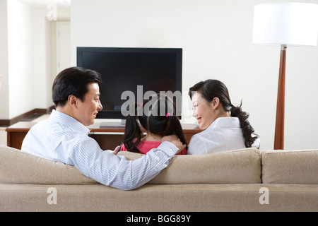 Paar mit Kind vor Breitbild-Fernseher Stockfoto