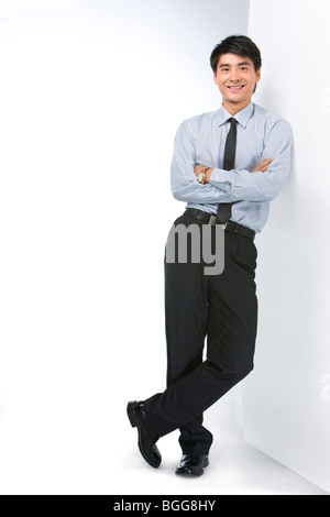 Junge Unternehmer stehend gegen eine Wand Stockfoto