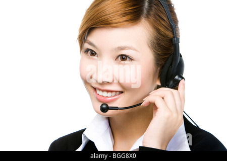 Junge Geschäftsfrau tragen Telefon Kopfhörer, lächelnd, Nahaufnahme, Stockfoto