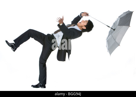 Jungunternehmer im Wind weggeblasen Stockfoto