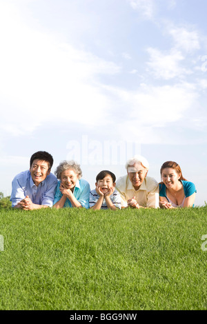 Drei-Generationen-Familie auf der Wiese liegend Stockfoto