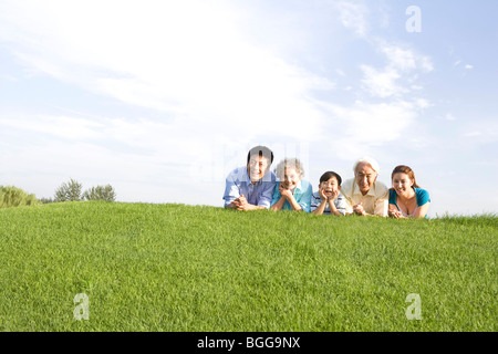 Drei-Generationen-Familie auf der Wiese liegend Stockfoto