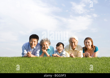 Drei-Generationen-Familie auf der Wiese liegend Stockfoto