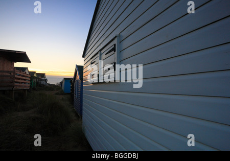 Strandhütten an alten Hunstanton an der Küste von Norfolk bei Sonnenuntergang. Stockfoto