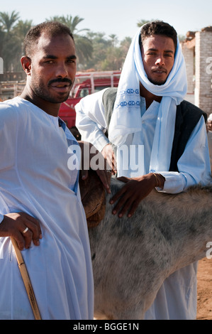 Zwei ägyptische junge Männer mit Schnurrbärte Verkauf Tiere in einem Viehmarkt im Niltal Stockfoto