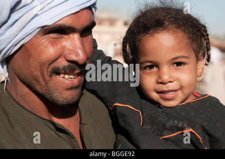 Jungen ägyptischen Vater mit seiner Tochter in Zöpfen auf einem Kamel Markt entlang des Nils. Stockfoto