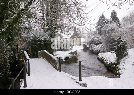 Die Pack Horse Bridge und ford in Bide Brook, Lacock im Winterschnee.Wiltshire England Großbritannien Stockfoto