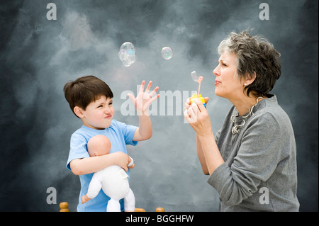 Mittlere gealterte Frau kaukasischen lehrt 3 1/2 Jahre alter Junge Luftblasen durchbrennen. Bild ist Modell veröffentlicht. Stockfoto