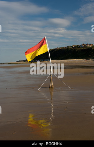 sicher in der Flagge am verlassenen nassen Strand von Cromer North Norfolk Vereinigtes Königreich Baden Stockfoto