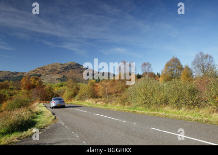 Ben Venue im Herbst, Berg im Loch Lomond & Trossachs National Park, und ein bewegungsunscharfes Auto auf der Dukes Pass Road Trip A821, Schottland, Großbritannien Stockfoto