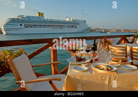 Stühle und Tische auf der Terrasse des Hotel Cipriani, Kreuzfahrtschiff vorbei, Giudecca, Venedig, Italien Stockfoto