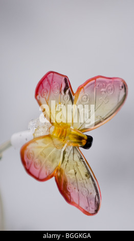 Beleuchteten Kunststoff Schmetterlinge, angetrieben von einem Solar-Panel mit Schnee in den Boden zurück. Stockfoto