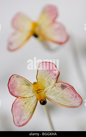 Beleuchteten Kunststoff Schmetterlinge, angetrieben von einem Solar-Panel mit Schnee in den Boden zurück. Stockfoto
