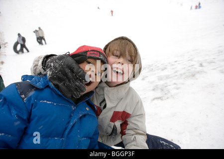 zwei sieben Jahre alten Jungen, albern, dass spielen im Schnee Stockfoto