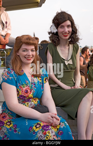 Zwei Frauen Lächeln, als sie im zweiten Weltkrieg der 1940er Jahre gekleidet sind, die im Mid-Atlantic Air Museum des zweiten Weltkriegs Wochenende Vintage Kleider Stockfoto