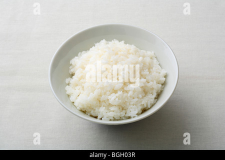 Plain gekochtem Reis in eine Schüssel geben. Stockfoto