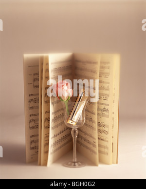 Musik und eine Rose und Mundharmonika in einem Glas öffnen Stockfoto