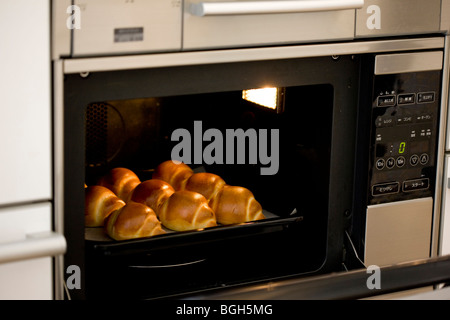 Brötchen backen im Ofen Stockfoto