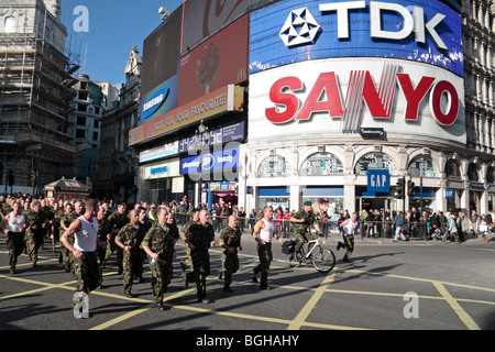 Soldaten der britischen Armee joggen durch Piccadilly Circus, Central London, England am einen Sponsorenlauf her Liebe. Nov 2009 Stockfoto