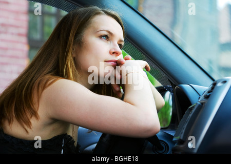 Müde junge Frau ruht im Auto. Stockfoto